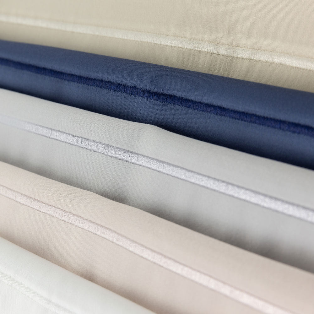 Close-up of fabric with sateen stich beige, blue, gray, and white.